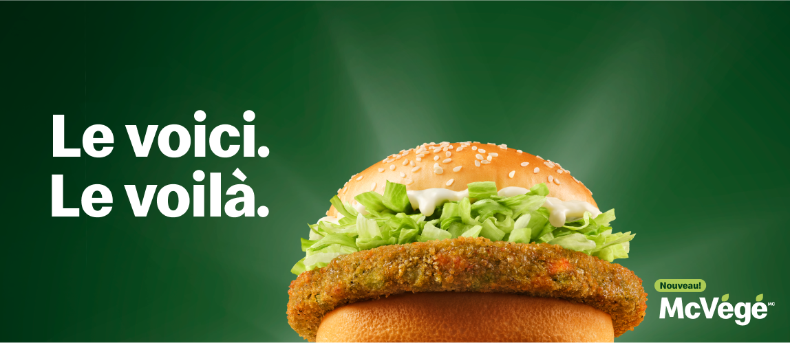 Un McVégéMC avec les mots « Le voici. Le voilà. » à sa gauche ainsi que « Nouveau! » et « McVégéMC » à sa droite.