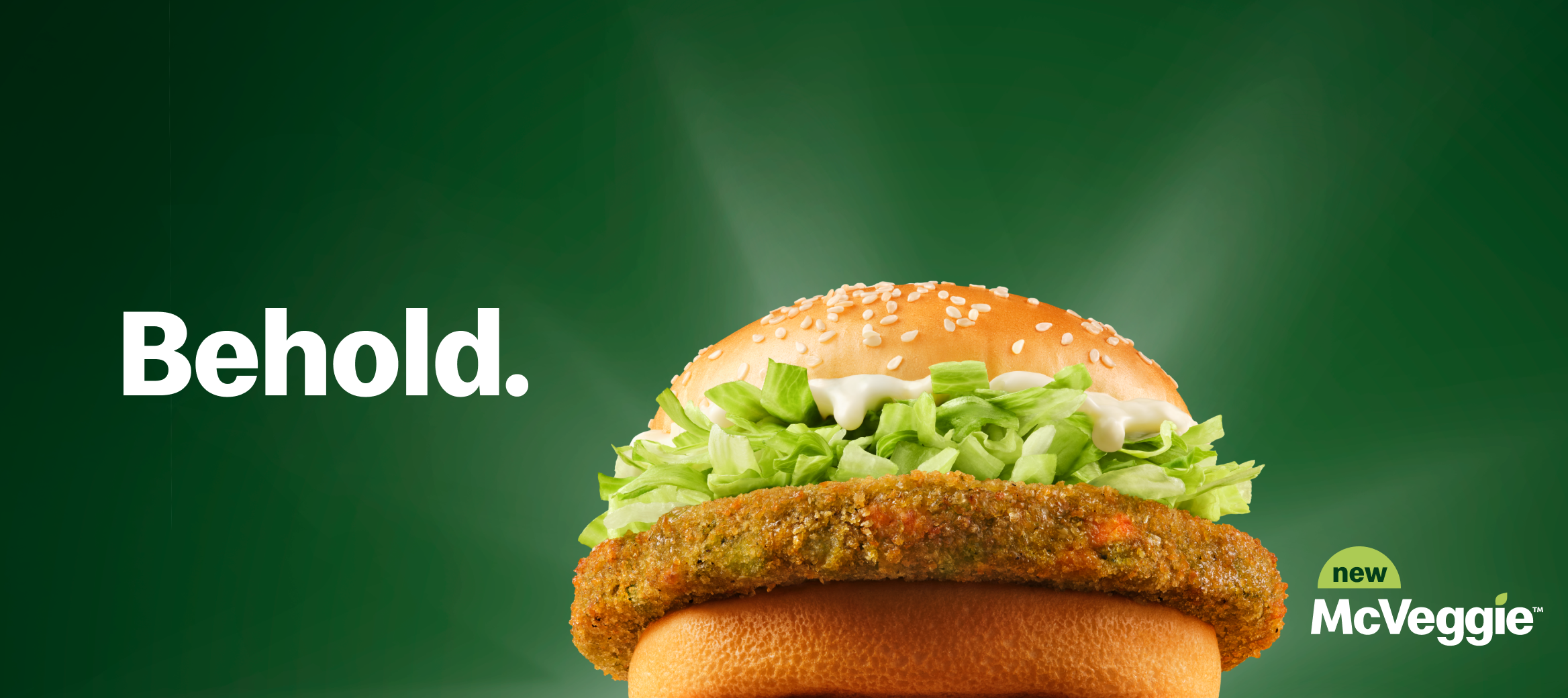 A McVeggie™ with the word ‘Behold’ on the left of it and the words ‘new’ ‘McVeggie™’ beside it on the right. 