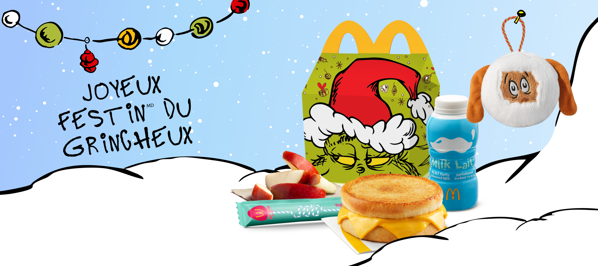 La boîte du Joyeux festinMD du Grincheux, des tranches de pomme, une bouteille de lait, un sandwich au fromage fondant, et une décoration des Fêtes sous le thème du Grincheux placés à côté des mots « Joyeux festin du Grincheux »