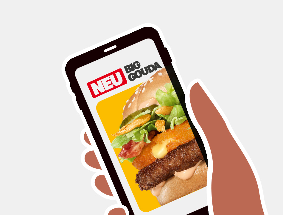 Eine Hand hält ein Smartphone hoch, auf dessen Screen der neue Big Gouda gezeigt wird.