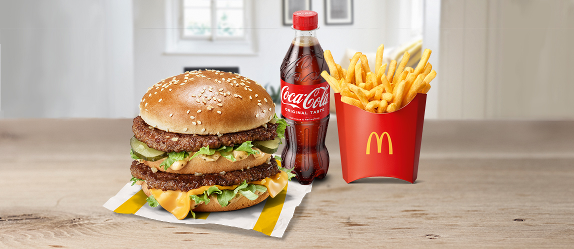 Wir sehen einen Burger, Pommes und eine Flasche Coca Cola