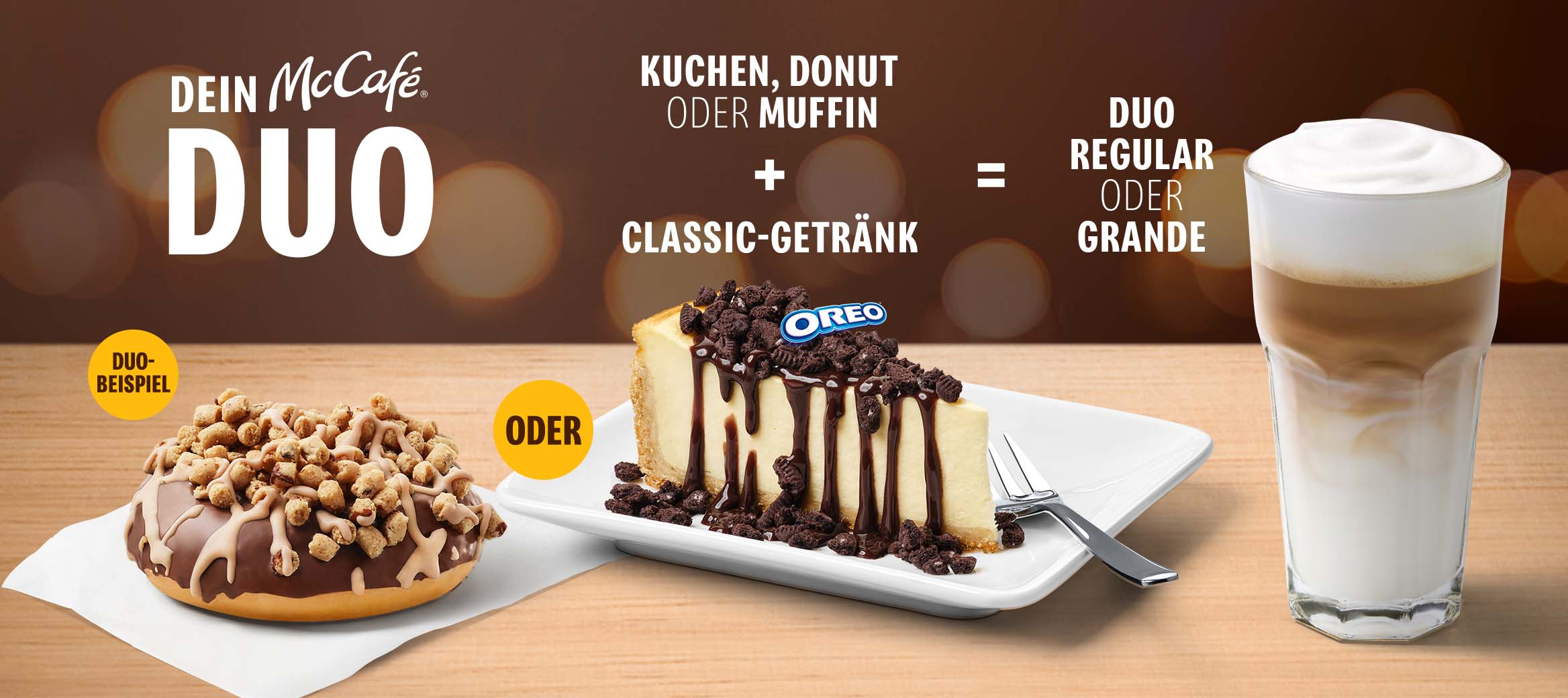 Mechanik des McCafé® DUOs. Kuchen oder Donut oder Muffin plus Classic-Getränk sind dein McCafé® DUO. Im Vordergrund ein Cookie Dough Donut und ein N.Y. Style Cheesecake mit OREO®-Topping und Schoko-Sauce sowie ein Latte Macchiato.