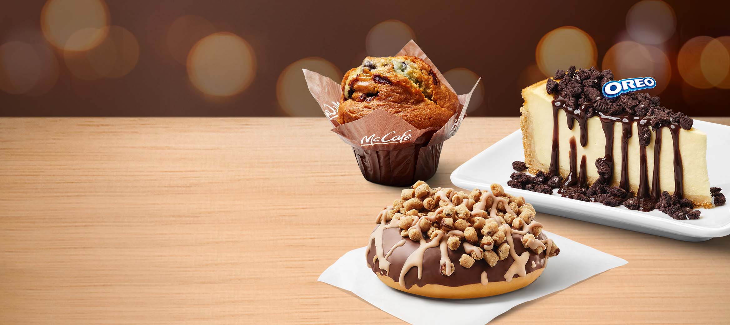 McCafé® Blaubeer Muffin, N.Y. Style Cheesecake mit OREO®-Topping und Schoko-Sauce und Cookie Dough Donut