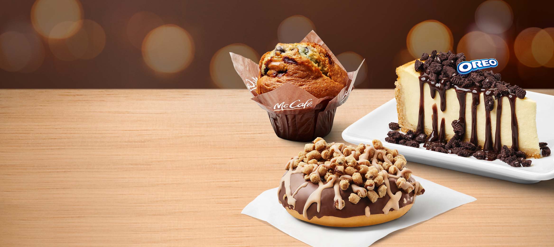 McCafé® Blaubeer Muffin, N.Y. Style Cheesecake mit OREO®-Topping und Schoko-Sauce und Cookie Dough Donut
