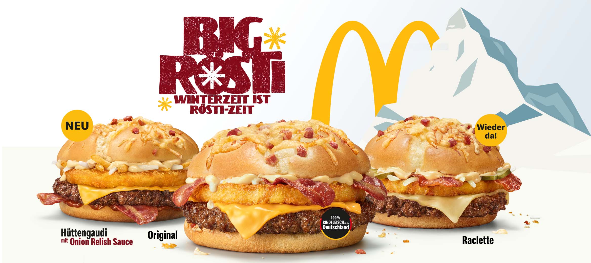 Wir sehen drei verschiedene Big Rösti vor einem schneebedeckten Berg.