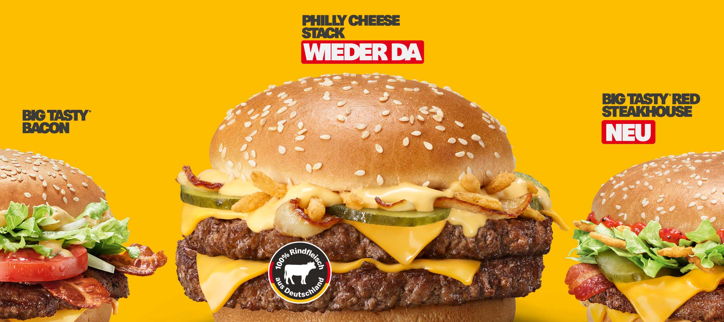 Philly Cheese Stack in der Mitte, Big Tasty® Bacon links, Big Tasty® Red Steakhouse rechts, auf gelbem Hintergrund