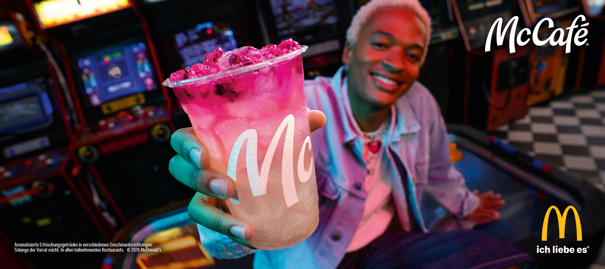 Eine Person hält einen McCafé Pink Dragonfruit Fizzer mit Sprite in der Hand