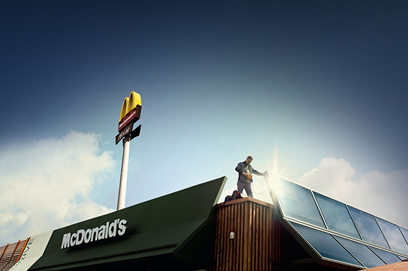 Techniker prüft Solaranlage auf dem Dach eines McDonald's Restaurants