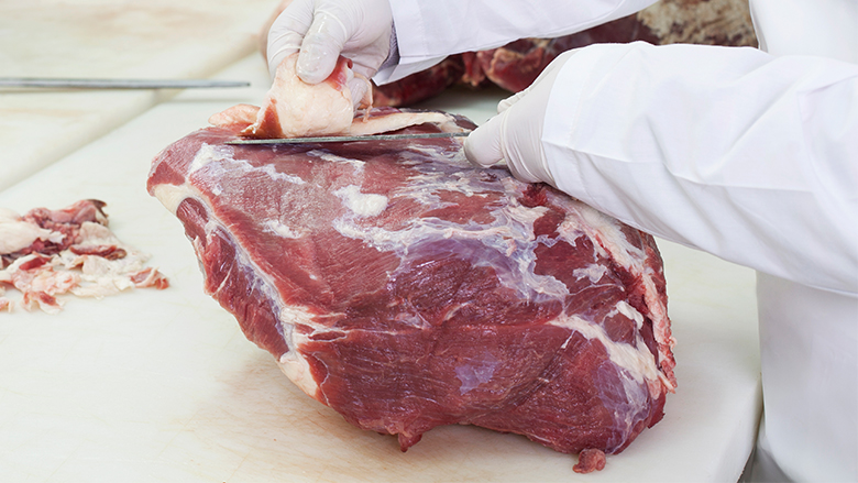 Von einem Stück Rindfleisch wird eine Scheibe heruntergeschnitten.