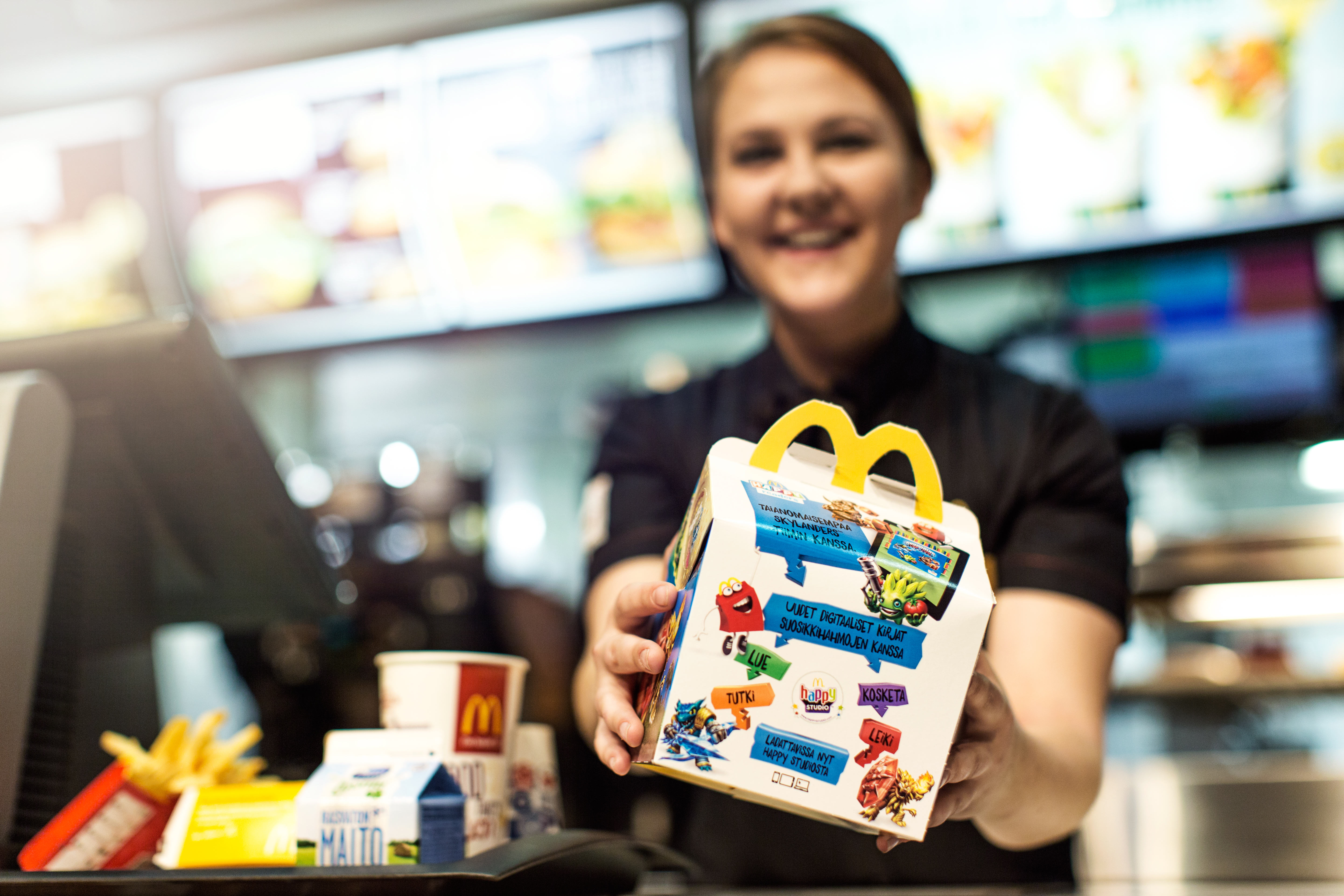 Työntekijä Happy Meal™ -lastenaterian kanssa 