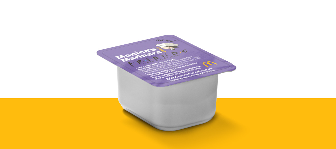 A small dipping pot with a purple lid labelled “Monica’s Marinara,” inspired by Friends, shown against a yellow background.