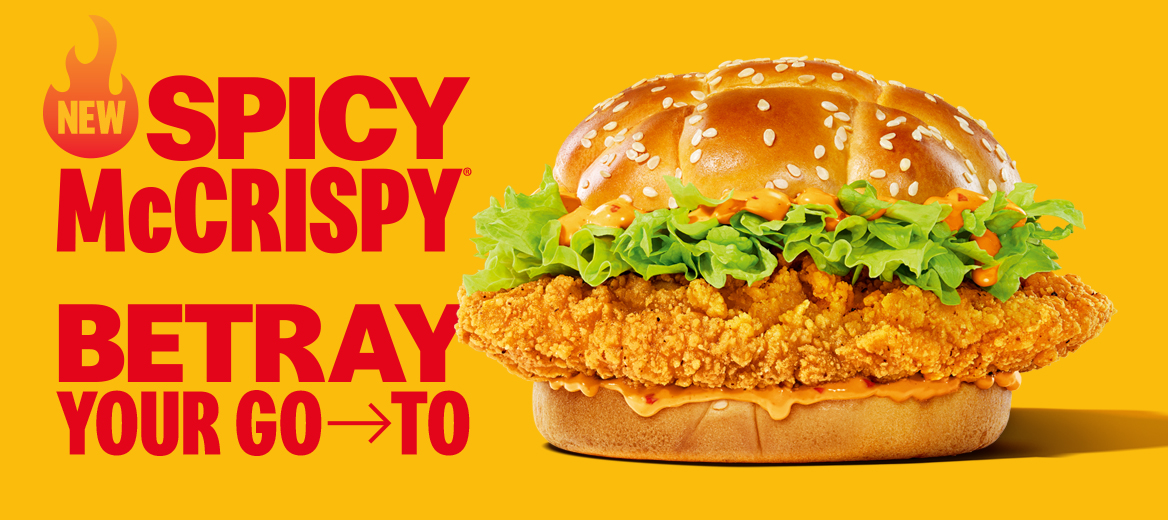 Spicy McCrispy burger on a plain yellow background with the line “Spicy McCrispy. Betray your go-to” next to it.