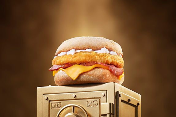 McDonald’s Chicken & Bacon McMuffin® sits on top of a gold vault .