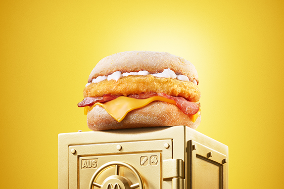 McDonald’s Chicken & Bacon McMuffin® sits on top of a gold vault .