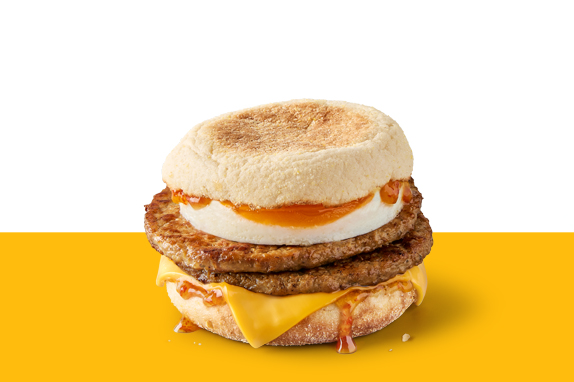 Double sausage and egg McMuffin with cheese and Hot Honey sauce on a toasted English muffin.