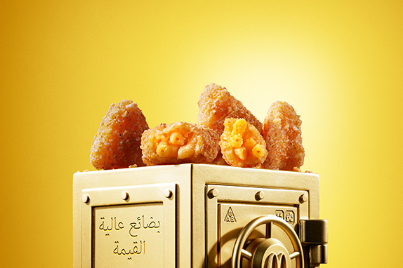 McDonald’s Mac & Cheese Triangles sits on top of a gold vault. 