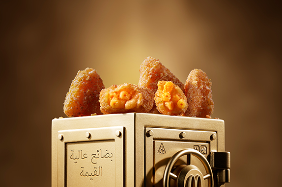 McDonald’s Mac & Cheese Triangles sits on top of a gold vault. 
