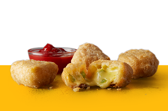 Four chilli cheese bites on yellow shelf with dip.