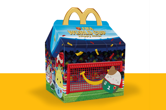 McDonald’s Happy Meal box designed like a football stadium, filled with colourful Squishmallows characters and a goal on the front.