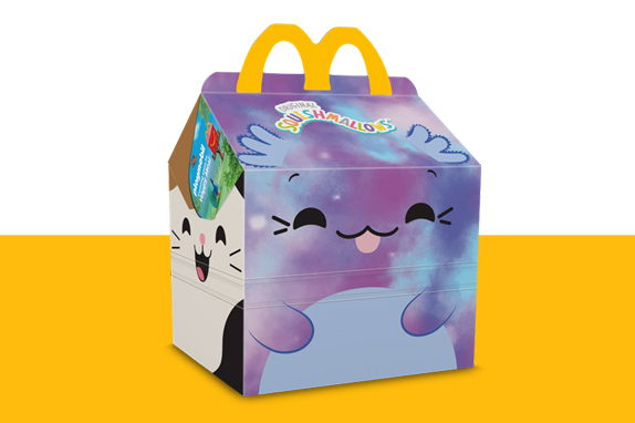 Squishmallows characters on a Happy Meal box on a yellow shelf  