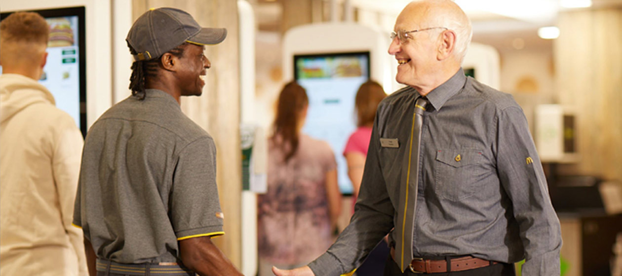 Two restaurant workers smiling at each other.