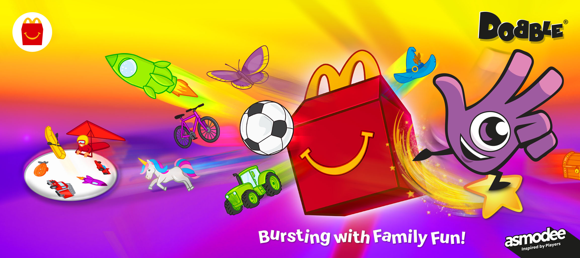 A bright, colourful scene with the Dobbly and a Happy Meal box surrounded by flying illustrated objects like rockets, animals, bikes and treasure chests.