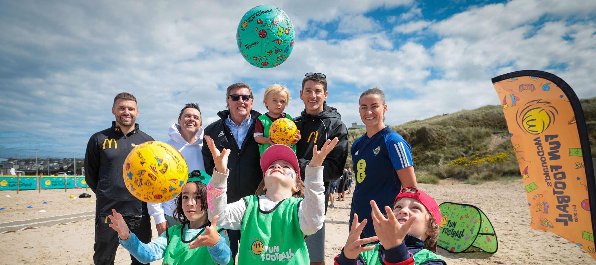 Kids at a Fun Football event on a pitch with a ball.
