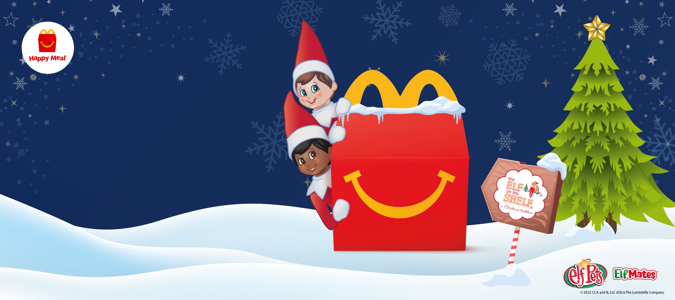 Happy Meal box with two Elf Mates hiding behind it, a Christmas tree and snow.