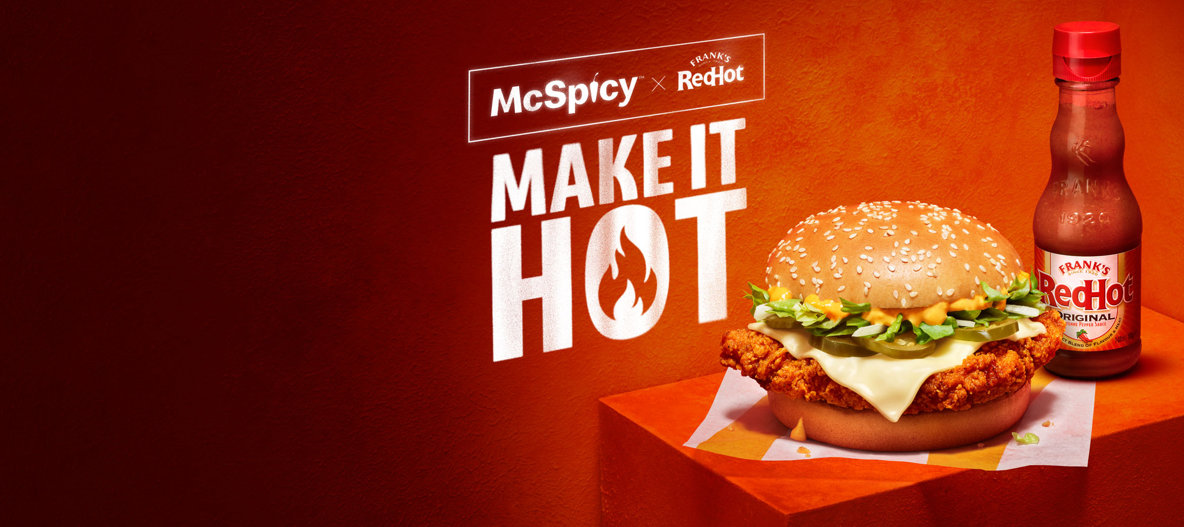 McSpicy burger next to the Frank’s RedHot® on a fiery red background