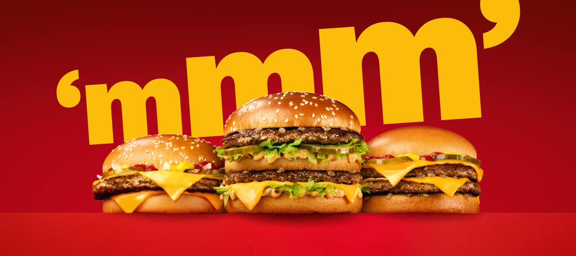 Three burgers on a red plinth and a red background.