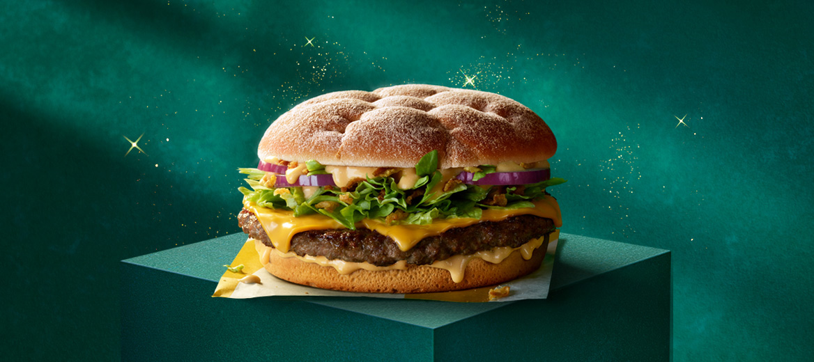 A McDonald’s beef burger on a green plinth with a green starry background.