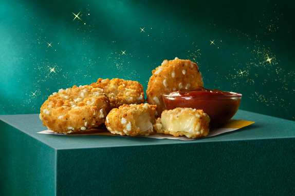 Cheese melt dippers on a green plinth with a green starry background.