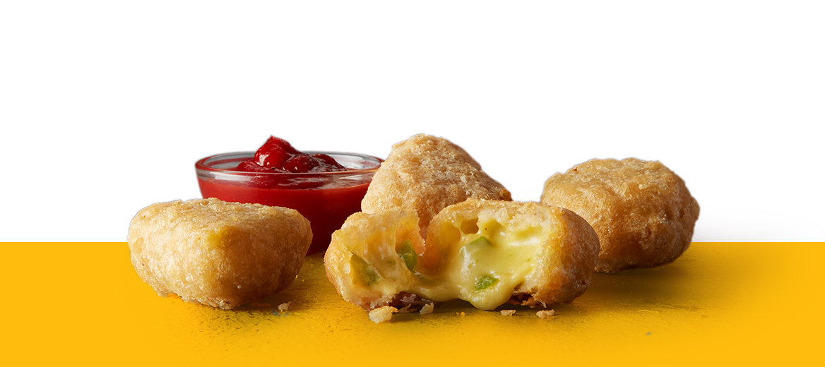 Four chilli cheese bites on yellow shelf with dip.