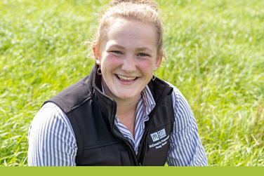Young female farmer smiles in a field