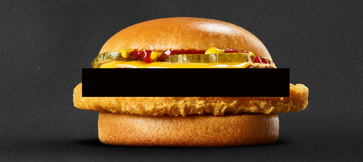 Image of the McDonald’s Chicken Cheeseburger on a black background.