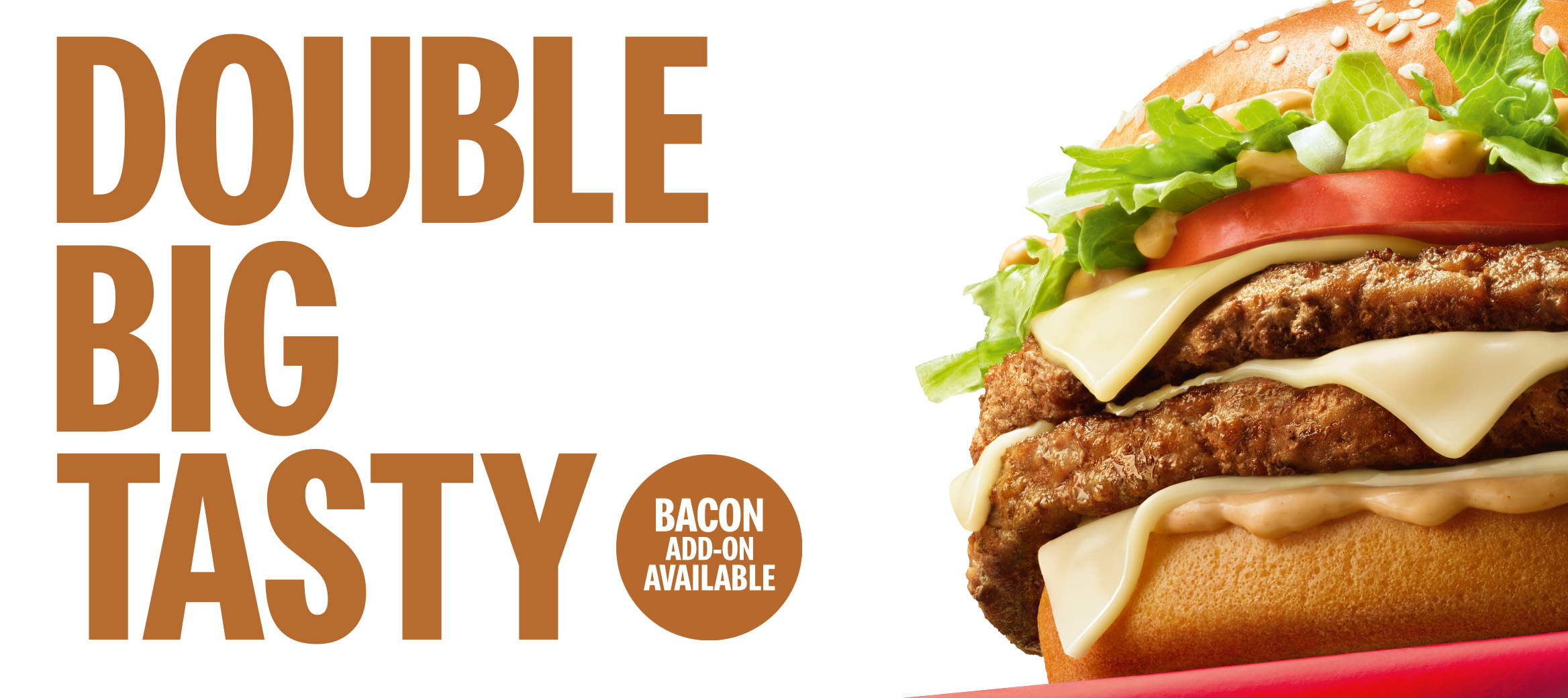The double big tasty on a red platform in the corner on a white background with “Double Big Tasty. Bacon add-on available” next to it. 