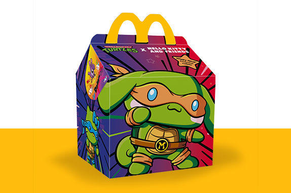 McDonald’s Happy Meal box featuring a green cartoon Kitty Ninja Turtle character with an orange mask and “M” belt on a colourful background.