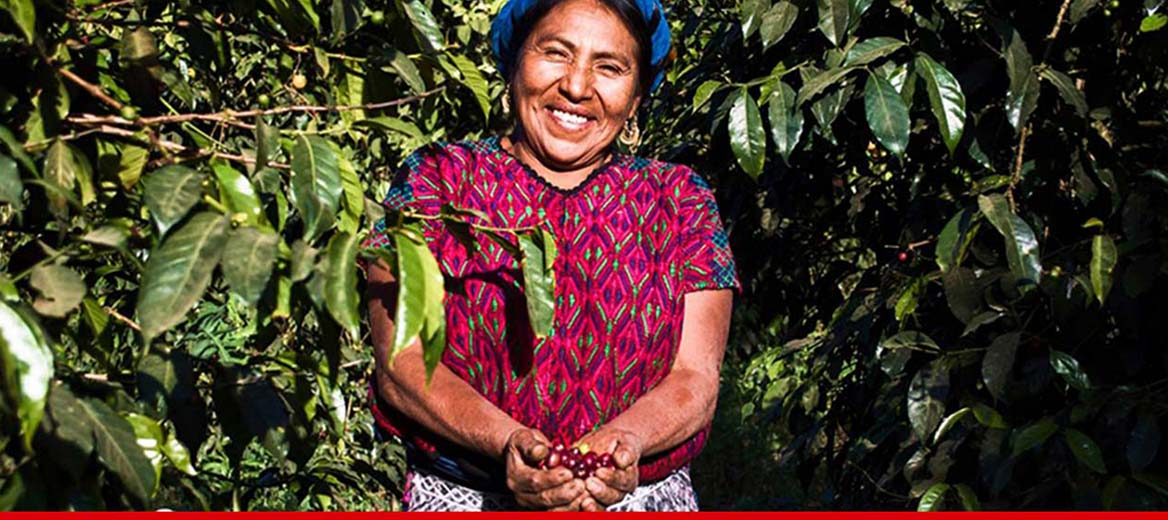 Female farmer smiling around her crops.