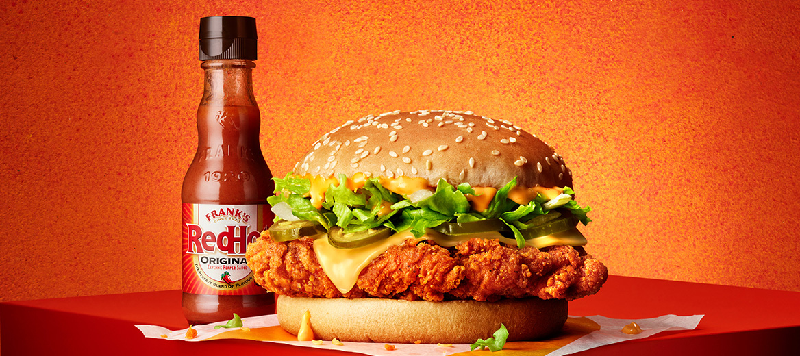 McSpicy Burger with the Franks Extra Hot  Sauce on a fiery, red-coloured background. 