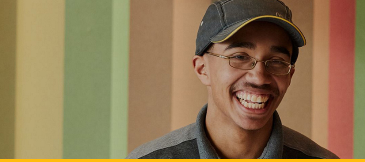 A McDonald's restaurant worker smiling. 