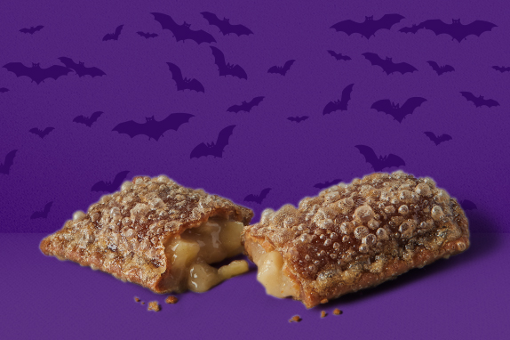 A purple background with bats flying and a pie.