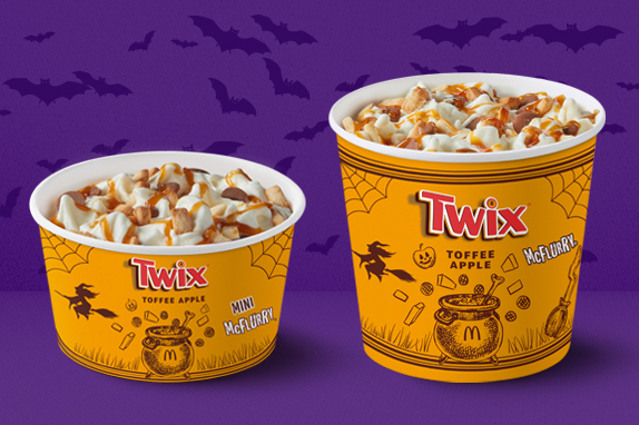  A purple background with bats flying and two McFlurry ice creams on Halloween packaging.