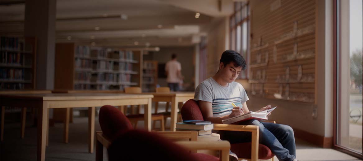 el estudiante lee en la biblioteca